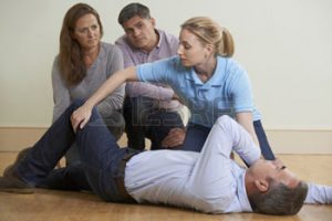 46779210-woman-demonstrating-recovery-position-in-first-aid-training-class